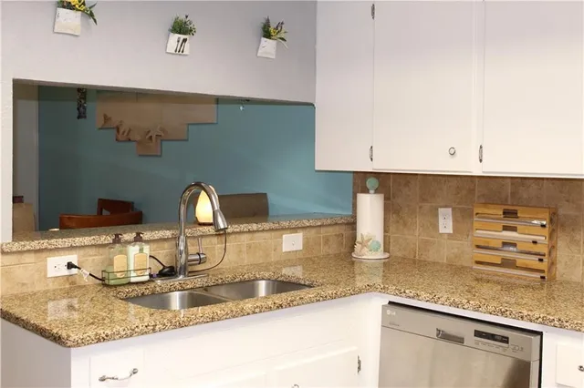 a kitchen with granite countertop a sink and cabinets