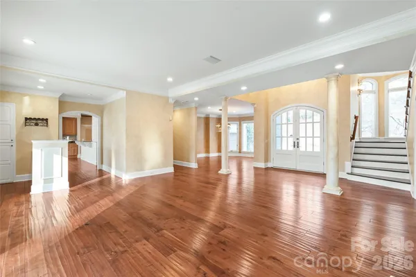 a view of an empty room with wooden floor and a floor to ceiling window