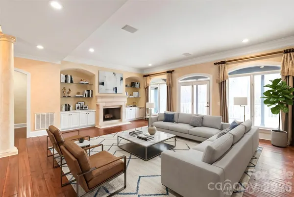 a living room with furniture fireplace and a large window