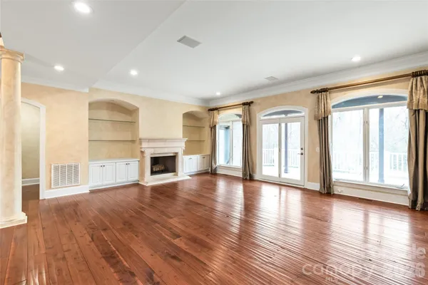 a view of a livingroom with wooden floor and a fireplace