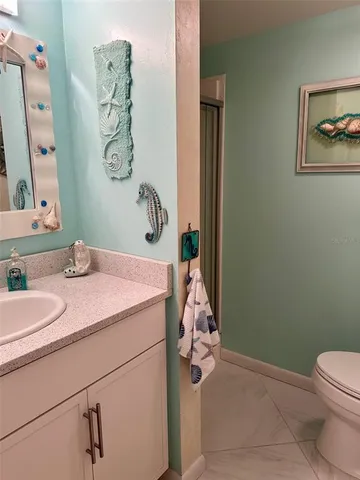 a bathroom with a sink vanity mirror and toilet