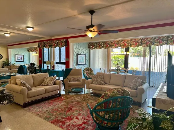 a living room with furniture a chandelier and a large window