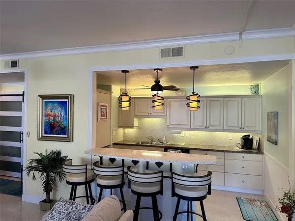 a kitchen with granite countertop white cabinets and chairs