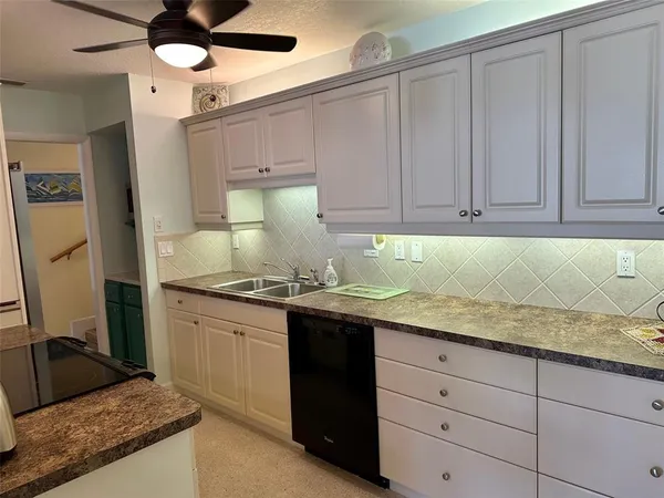 a kitchen with granite countertop a sink stainless steel appliances and cabinets