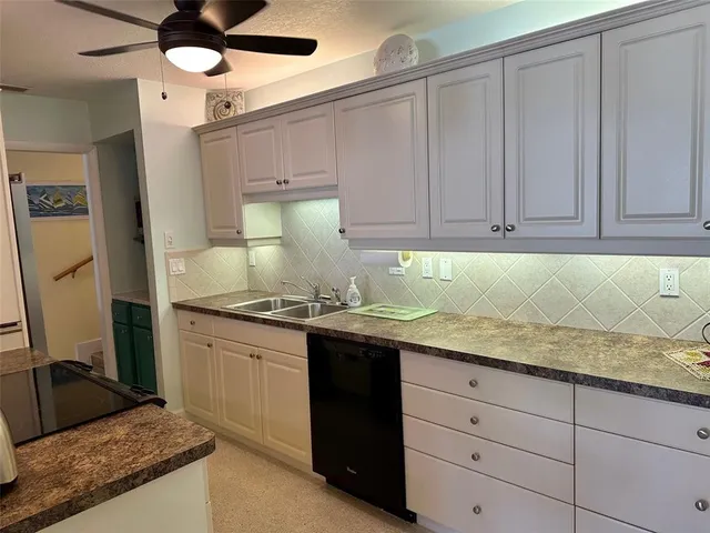 a kitchen with granite countertop a sink stainless steel appliances and cabinets