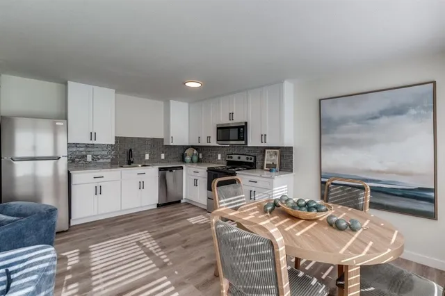 a kitchen with stainless steel appliances kitchen island granite countertop a sink refrigerator and cabinets