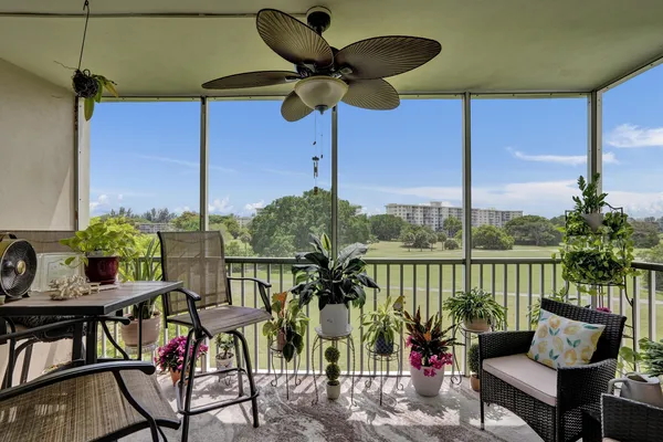 a view of a balcony with chairs and a potted plant
