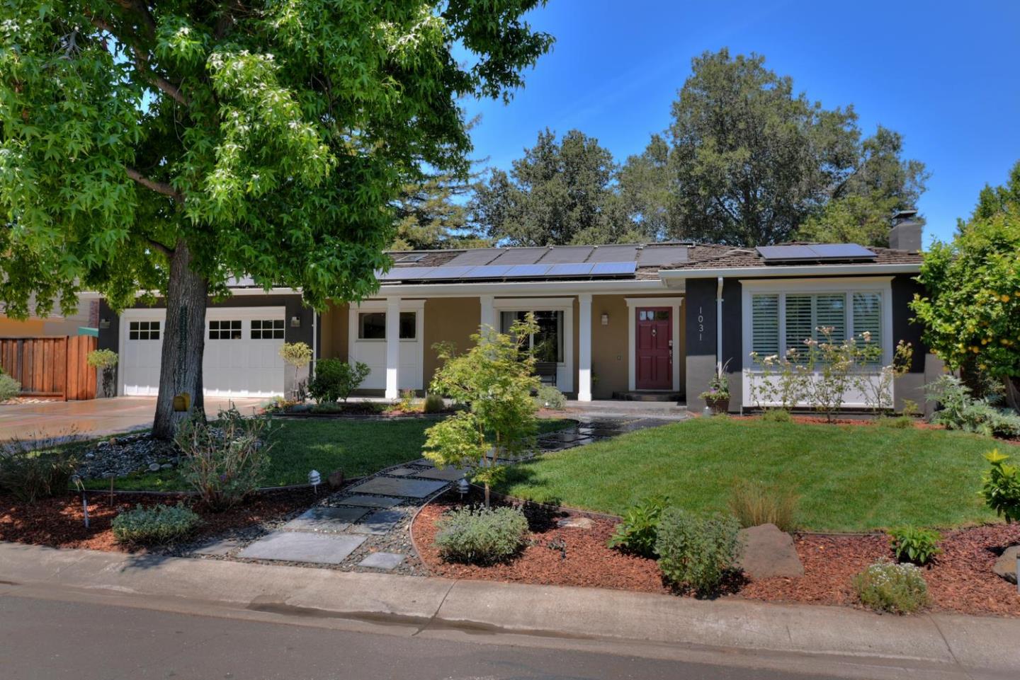 a front view of a house with a yard and potted plants