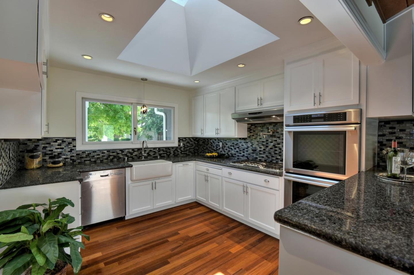 1031 Suffolk Way Los Altos, CA 94024 - Photo 10 of 26 a kitchen with stainless steel appliances kitchen island granite countertop a stove a sink and a microwave