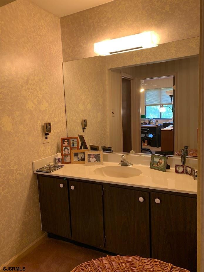 16 Greenbriar Road Marmora, NJ 08223 - Photo 25 of 37 a bathroom with a double vanity sink and a mirror