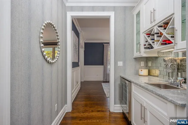 a hallway with painting on the wall and a potted plant