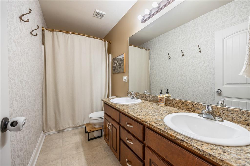 19 Isbell Road Fort Mitchell, AL 36856 - Photo 27 of 37 Dual vanity with individual basin sinks, granite-finish countertop, wood-finish cabinetry, and a full-width mirror
