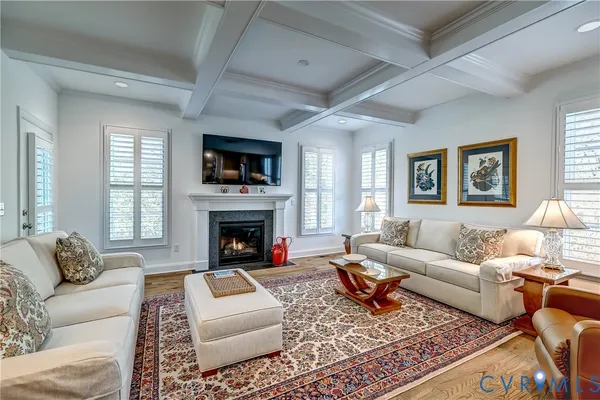 a living room with furniture a rug a window and a fireplace