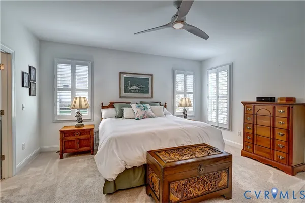 a bedroom with a bed a dresser and a large window