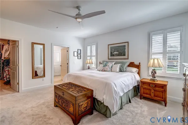 a spacious bedroom with a bed a dresser and a window