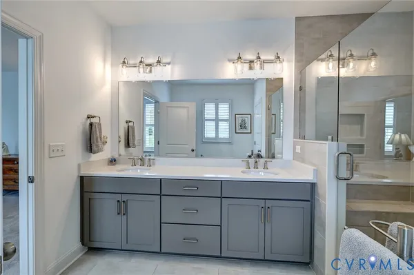 a bathroom with double vanity sinks and a mirror