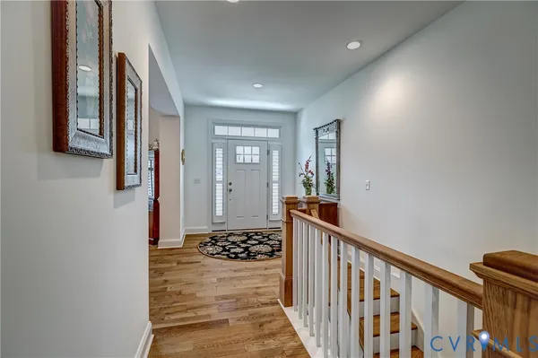 a view of a hallway with wooden floor and staircase