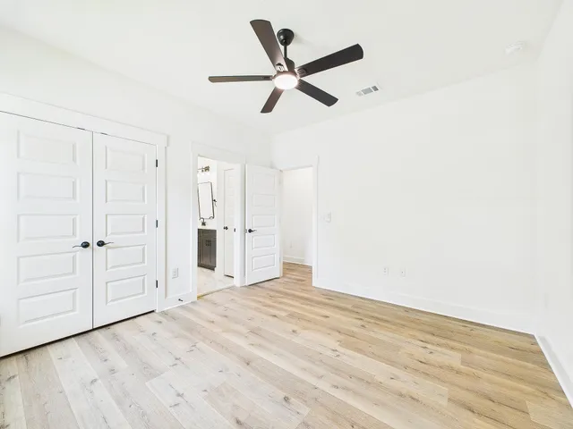 a view of a big room with wooden floor and a ceiling fan