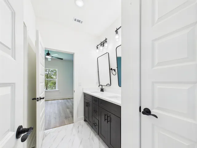 a view of empty room with wooden floor and ceiling fan