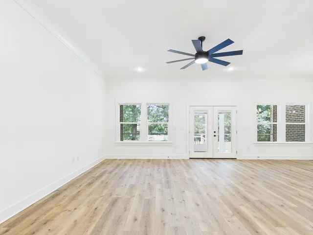 a large kitchen with stainless steel appliances kitchen island a large counter top and a wooden floors