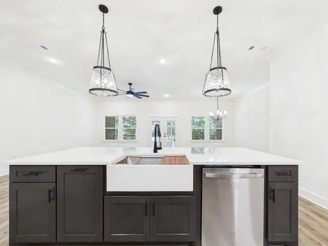 a large kitchen with stainless steel appliances granite countertop a sink a stove top oven a counter space and cabinets