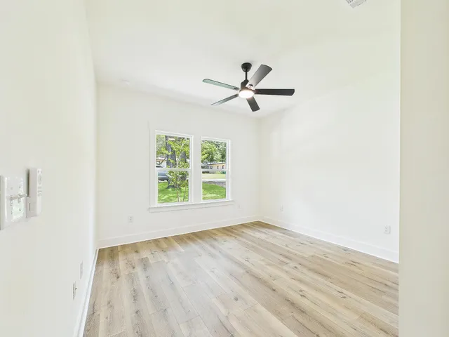 a bedroom with a large bed a chandelier and a window
