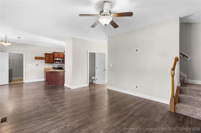 a view of empty room with wooden floor and ceiling fan