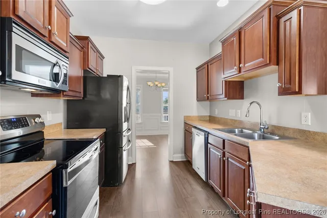 a kitchen with stainless steel appliances granite countertop a refrigerator a stove top oven a sink and dishwasher