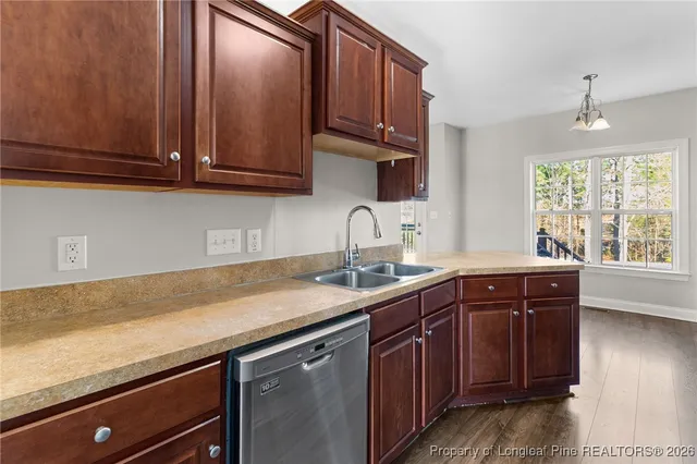 a kitchen with stainless steel appliances granite countertop wooden cabinets a sink and dishwasher