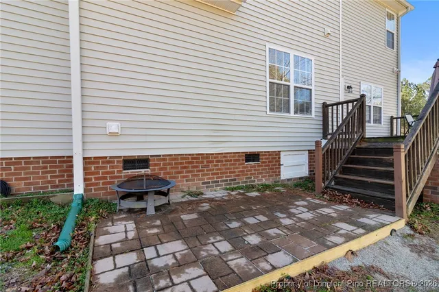 a backyard of a house with barbeque and wooden fence