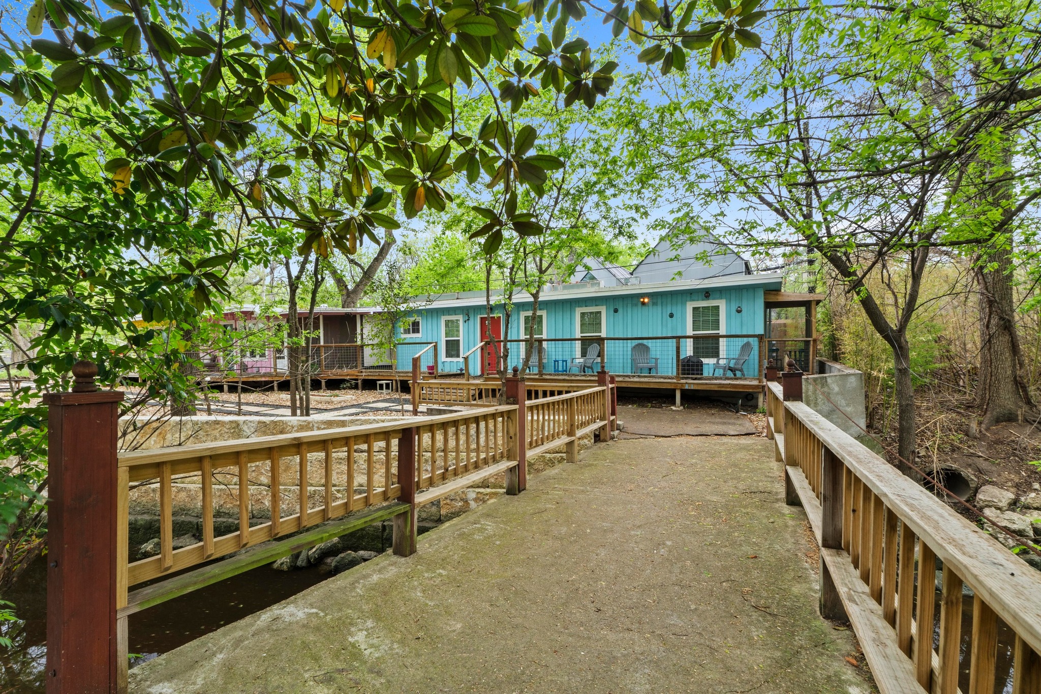 4512 Speedway, Unit A Austin, TX 78751 - Photo 3 of 39 Wood-railed walkway leading to a vibrant blue exterior with a covered porch