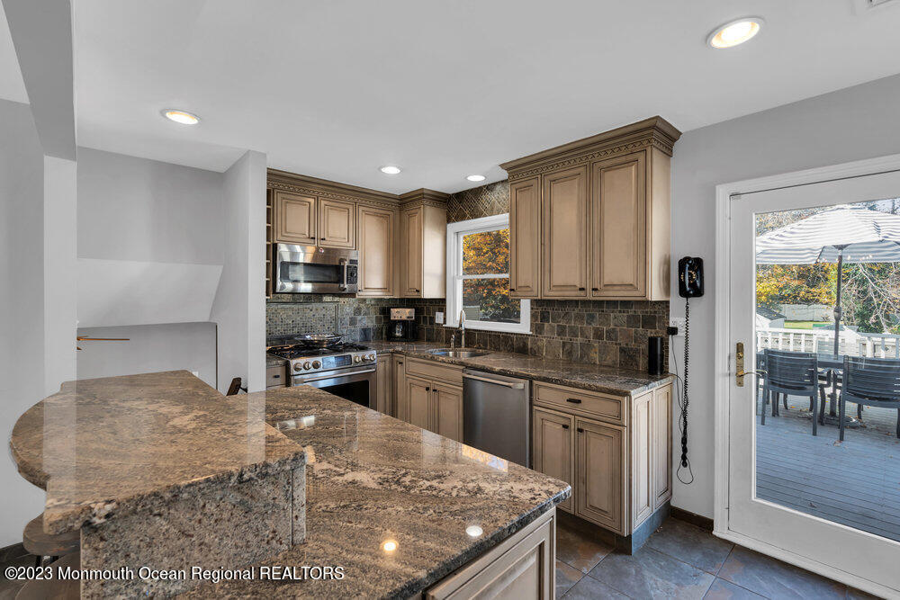 17 Eisele Avenue Asbury Park, NJ 07712 - Photo 34 of 52 a kitchen with stainless steel appliances granite countertop a stove top oven a sink dishwasher and a refrigerator with wooden floor