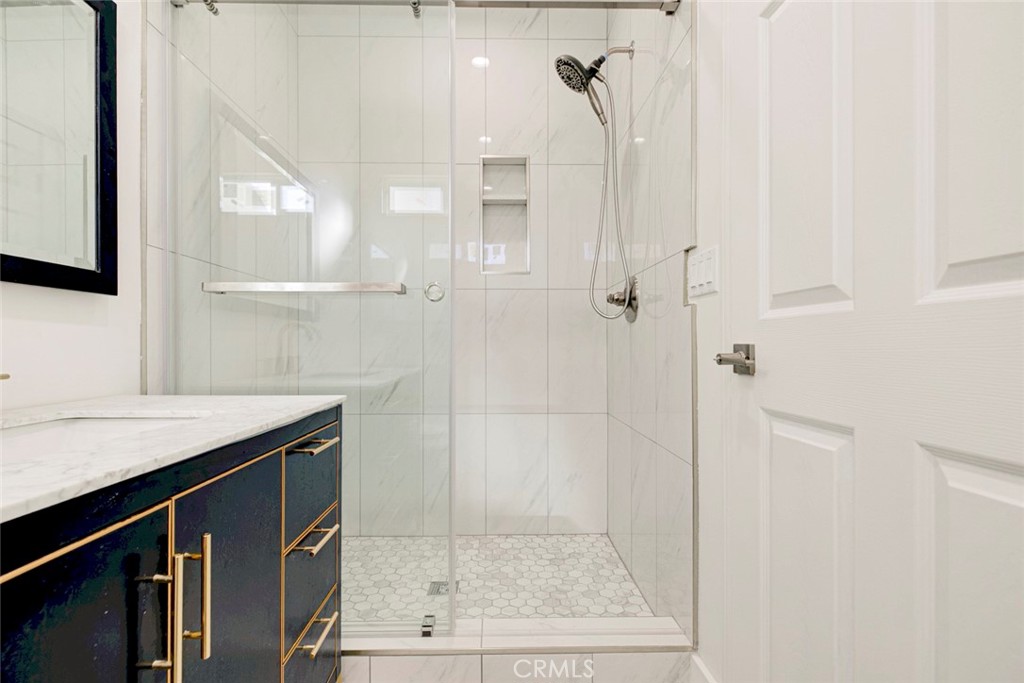 7846 Kyle Street Sunland, CA 91040 - Photo 11 of 12 a bathroom with a granite countertop sink a mirror and shower