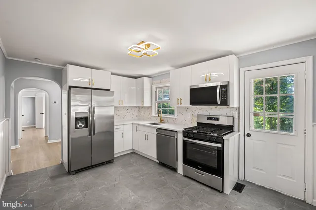 a kitchen with stainless steel appliances a stove a sink and a microwave