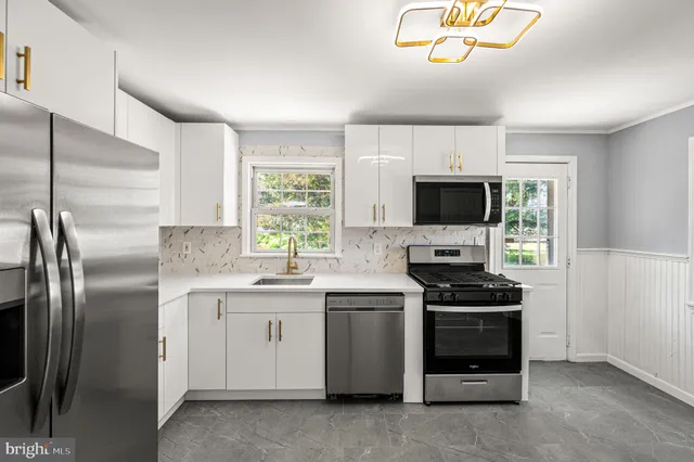 a kitchen with stainless steel appliances a stove a sink and a refrigerator