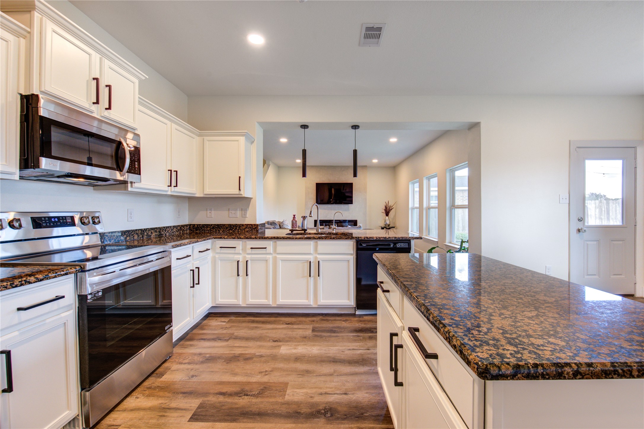 2003 Beach Bluff Road Rosenberg, TX 77469 - Photo 26 of 50 a kitchen with stainless steel appliances granite countertop a stove top oven a sink and a microwave