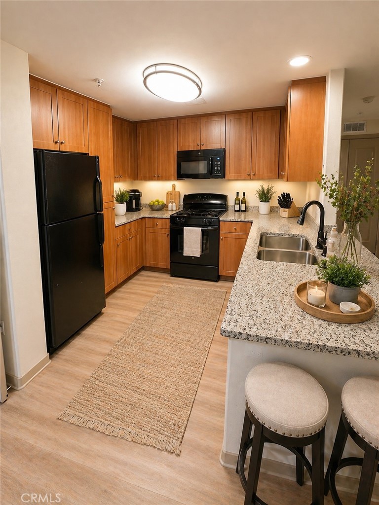 203 North San Dimas Canyon Road San Dimas, CA 91773 - Photo 4 of 11 a kitchen with granite countertop kitchen island stainless steel appliances a refrigerator a stove a sink a dining table and chairs