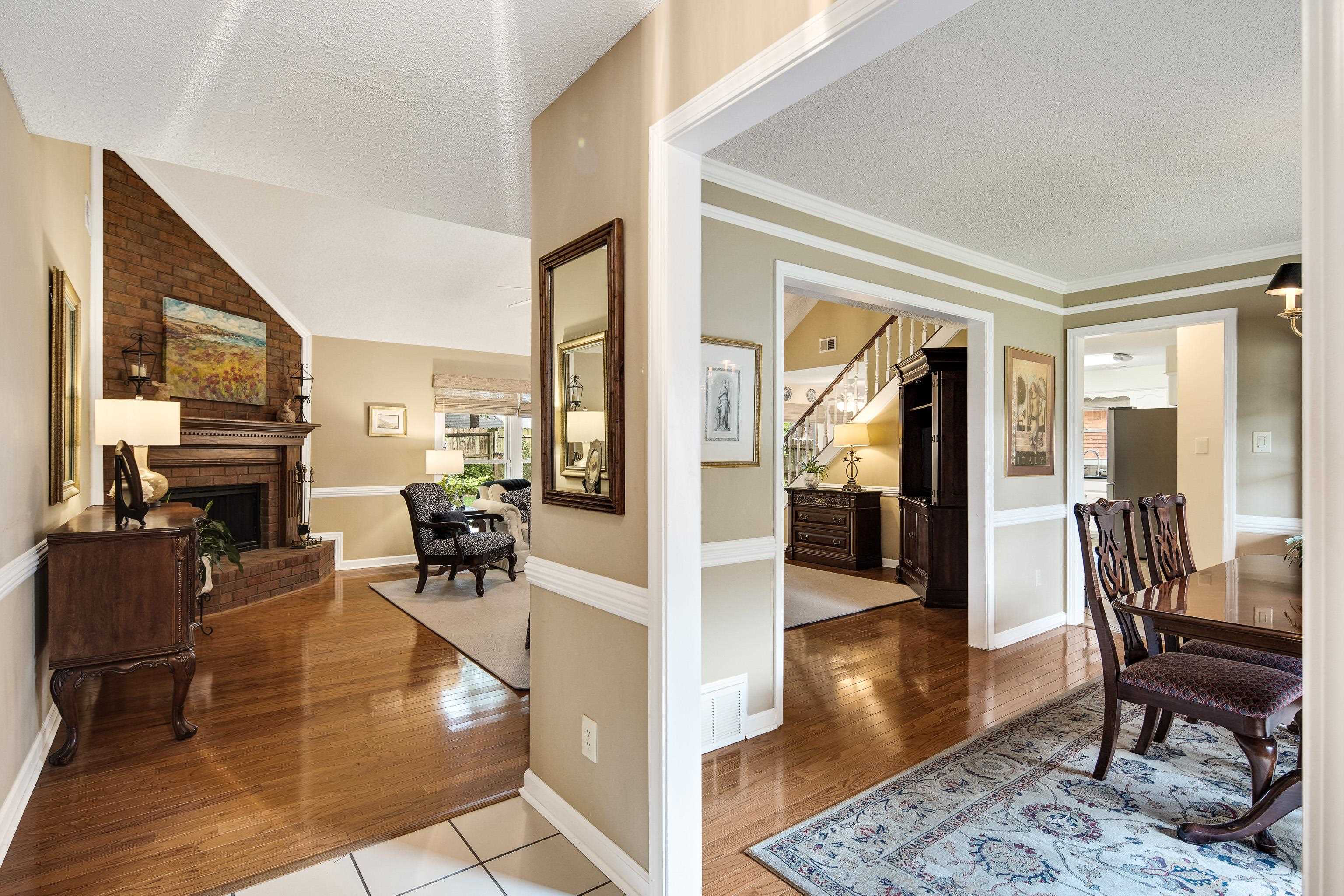 Hall featuring a textured ceiling, lofted ceiling, crown molding, and light hardwood / wood-style floors