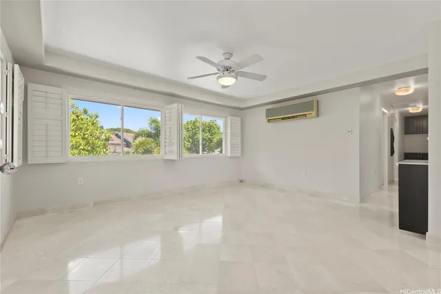 an empty room with windows and ceiling fan