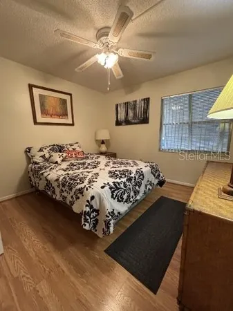 a bed sitting in a bedroom next to a window and a chandelier