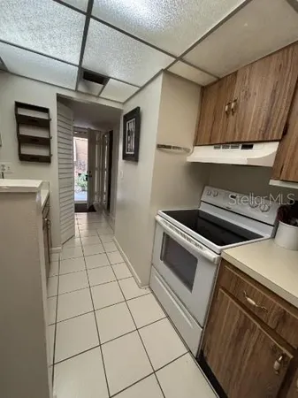 a kitchen with granite countertop a refrigerator and a stove top oven
