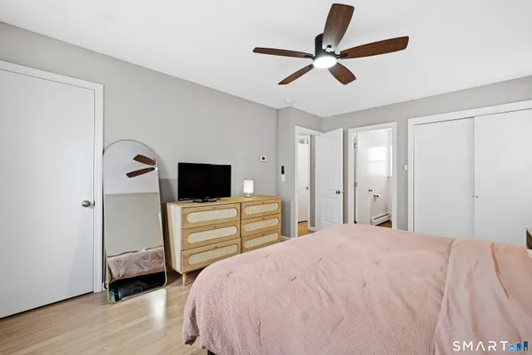 a bedroom with a bed and a flat tv screen on dresser