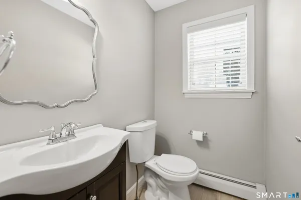 a bathroom with a sink toilet and a mirror