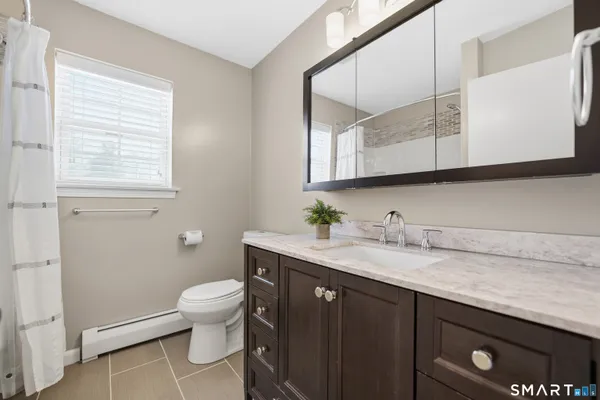 a bathroom with a granite countertop sink a toilet and mirror