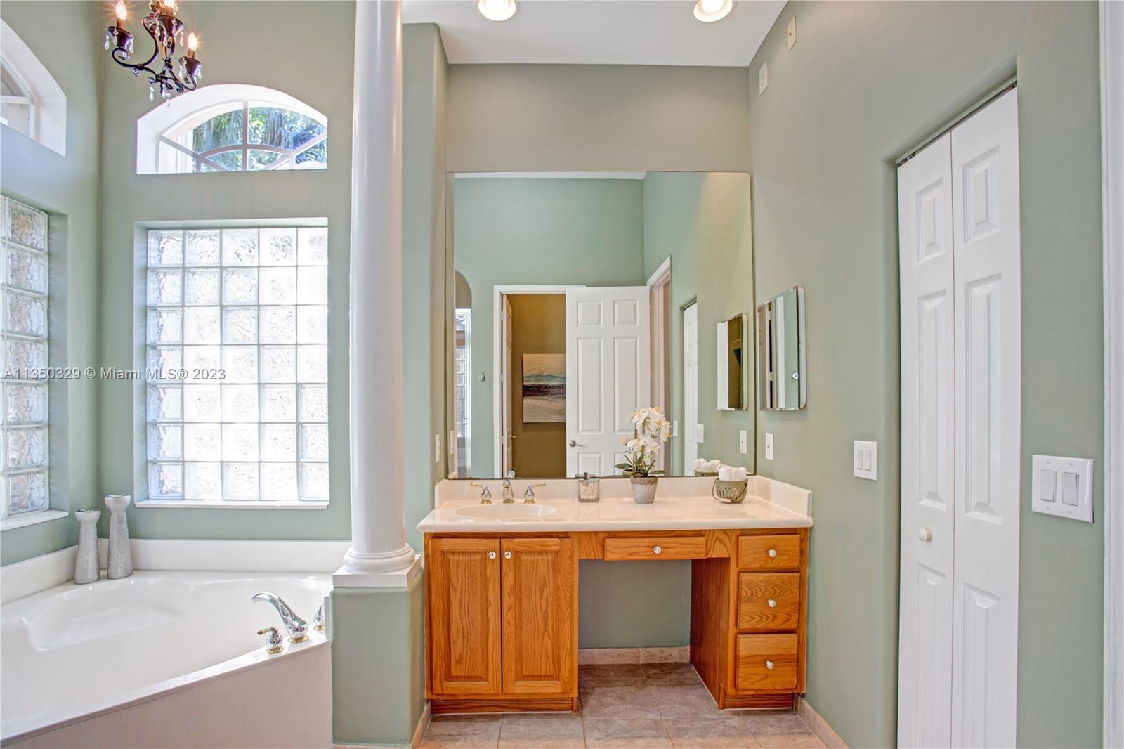 3060 Southwest 195th Terrace Miramar, FL 33029 - Photo 15 of 76 a bathroom with a bathtub a sink and a large mirror