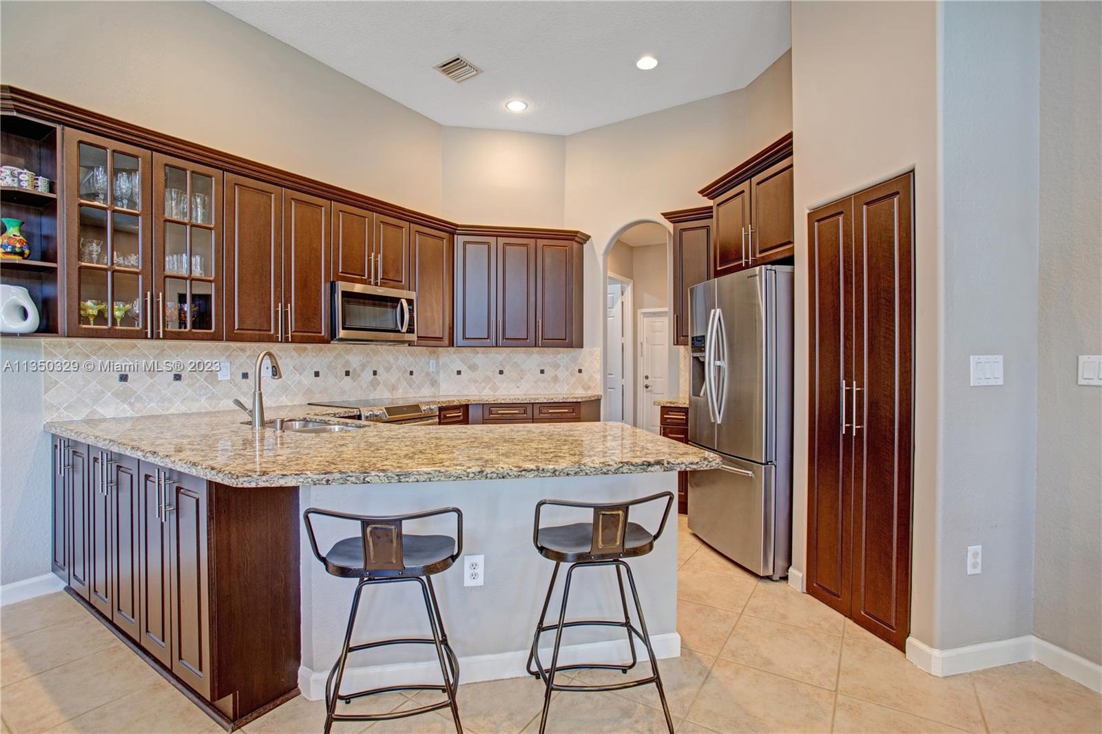 3060 Southwest 195th Terrace Miramar, FL 33029 - Photo 34 of 76 a kitchen with stainless steel appliances granite countertop a refrigerator and a stove top oven