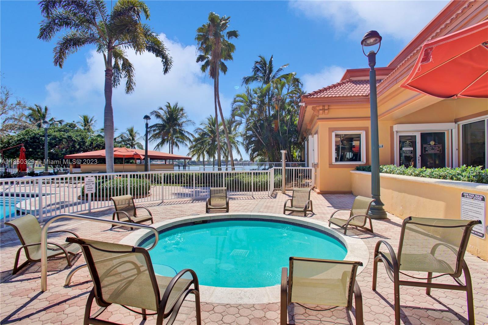 3060 Southwest 195th Terrace Miramar, FL 33029 - Photo 62 of 76 a view of a patio with table and chairs potted plants and palm trees