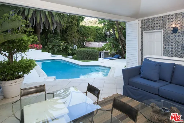 a living room with patio furniture and a potted plant