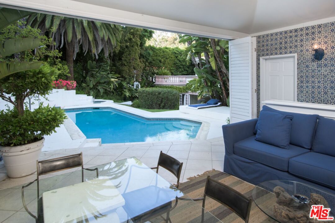 1241 Stone Canyon Road Los Angeles, CA 90077 - Photo 8 of 12 a living room with patio furniture and a potted plant