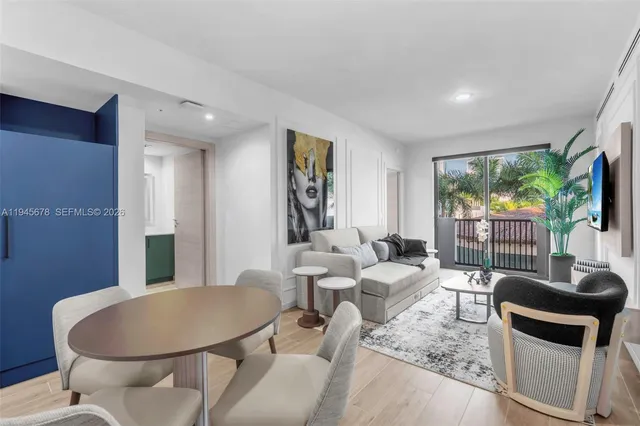 a living room with furniture a flat screen tv and a large window